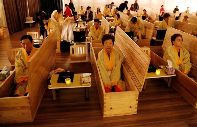 Participants sit inside coffins during a “living funeral” event as part of a “dying well” programme, in Seoul, South Korea, October 31, 2019. (Photo by Heo Ran/Reuters)