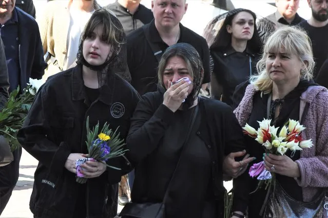 People cry during a funeral ceremony for Kira Glodan, three-month-old, her mother Valerya Glodan, 28, and grandmother Lyudmila Yavkina, 54, killed in their apartment by shelling, at the Transfiguration Cathedral in Odessa, Ukraine, Wednesday, April 27, 2022. According Ukrainian officials five people including a three-month-old infant were killed and 18 injured in a missile attack in the Black Sea port city of Odesa on last Saturday, April 23. (Photo by Max Pshybyshevsky/AP Photo)