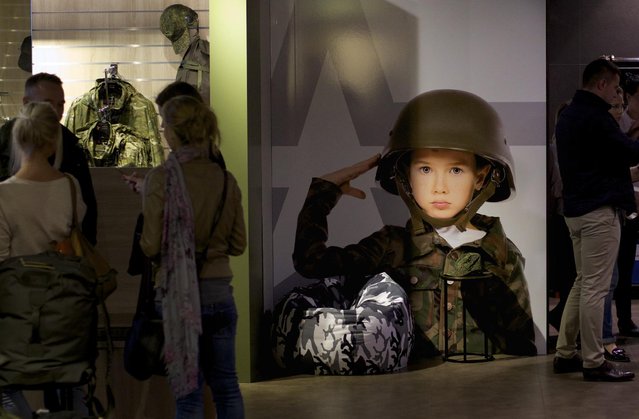 In this Tuesday, July 21, 2015 photo, customers visit an the  Russian Army store in downtown Moscow, Russia. The Russian Army Store opened earlier this summer in Moscow as an upmarket venue selling a wide range of patriotic goods – from mugs with Putin's portrait to limited-edition clothing like a leather jacket costing over $1,500. (Photo by Ivan Sekretarev/AP Photo)