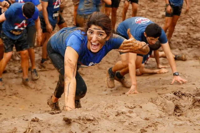 Participants climb a 10km muddy obstacle course during the “Run Mud” race, on March 29, 2019 in the Israeli mediterranean coastal city of Tel Aviv. (Photo by Jack Guez/AFP Photo)