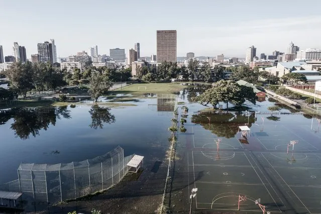 This aerial view shows sports fields under water days after heavy rains in Durban on April 15, 2022. The death toll from South Africa's “unprecedented” floods climbed to 341 on Thursday as helicopters fanned out across the southeastern city of Durban in an increasingly desperate search for survivors. With roads and bridges washed away by freak rainfall this week, rescuers battled to deliver supplies across the city, where some residents have been without power or water since April 11, 2022. (Photo by Marco Longari/AFP Photo)