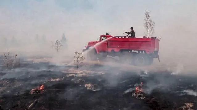 In this handout photo taken from video released by Russian Emergency Ministry Press Service on Tuesday, May 10, 2022, a firefighter works at the scene of a forest fire in Kurgan region, Russia. Russian President Vladimir Putin urged authorities on Tuesday to take stronger action to prevent wildfires and increase coordination between various official agencies in dealing with them. (Photo by Russian Emergency Ministry Press Service via AP Photo)