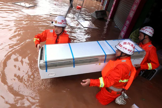 Rescuers move an electrical appliance from a shop at a flooded area in Luzhou, Sichuan Province, China, June 19, 2016. (Photo by Reuters/Stringer)