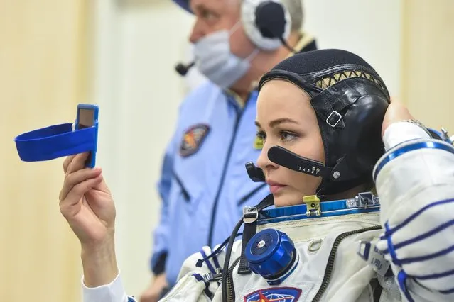 This handout photo taken and released on October 5, 2021 by Russian Space Agency Roscosmos shows Russian crew member, actress Yulia Peresild checking last deatils as her spacesuit is tested prior to the launch onboard the Soyuz MS-19 spacecraft at the Russian-leased Baikonur cosmodrome. A Russian actress and director arrived at the International Space Station (ISS) on October 5, 2021 to begin a 12-day mission to make the first movie in orbit. The Russian crew is set to beat a Hollywood project that was announced last year by “Mission Impossible” star Tom Cruise together with NASA and Elon Musk's SpaceX. (Photo by Andrey Shelepin/Russian Space Agency Roscosmos/AFP Photo)