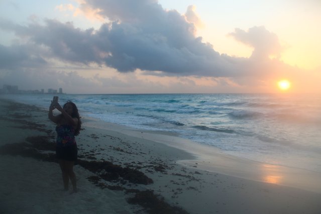 A woman takes a selfie on a beach ahead of the arrival of Hurricane Beryl, in Cancun, Mexico on July 4, 2024. (Photo by Raquel Cunha/Reuters)