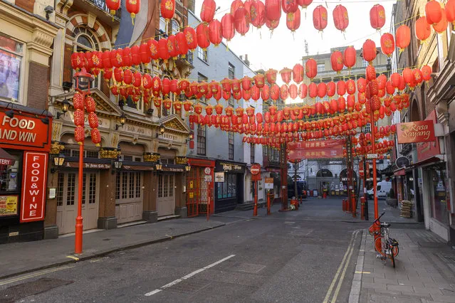 Pedestrians walk through the almost deserted streets of  London's China Town district on February 4, 2020. As the deadly 2019-nCov strain of coronavirus has spread worldwide, it has carried with it xenophobia – and Asian communities around the world are finding themselves subject to suspicion and fear. (Photo by Justin Tallis/AFP Photo)
