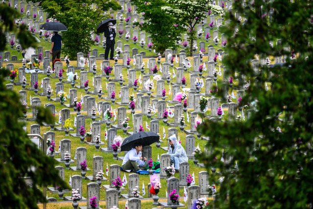 People visit graves at the National Cemetery as South Korea marks Memorial Day, which honours those who died during the 1950-53 Korean War and in other operations while serving their country, in Seoul on June 6, 2022. (Photo by Anthony Wallace/AFP Photo)
