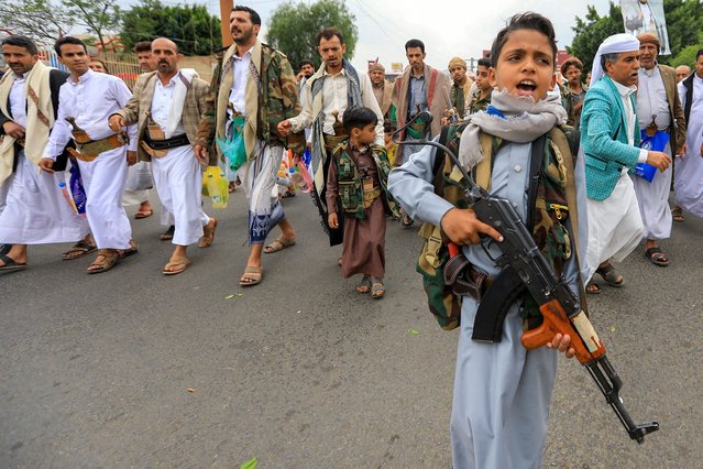 A boy holding a rifle chants slogans as Yemenis march in the Huthi-run capital Sanaa in solidarity with the people of Gaza on June 28, 2024, amid the ongoing conflict between Israel and the militant Hamas group in the Gaza Strip. (Photo by Mohammed Huwais/AFP Photo)