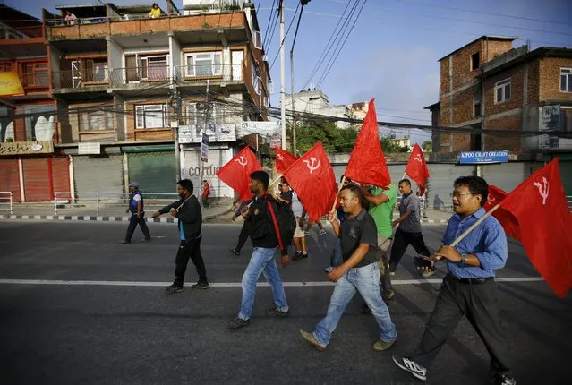 Protesters carrying party flags march on the road during a general strike organised by a 30-party alliance led by a hardline faction of former Maoist rebels, who are protesting against the draft of the new constitution, in Lalitpur, Nepal August 16, 2015. (Photo by Navesh Chitrakar/Reuters)