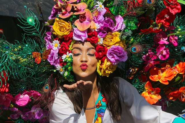 A young woman with indigenous attire and flower details blows a kiss during a traditional parade to inaugurate the Patron Saint Festivities to the “Divino Salvador del Mundo”, on August 1, 2023 in San Salvador, El Salvador. (Photo by Ariel Peña/APHOTOGRAFIA/Getty Images)