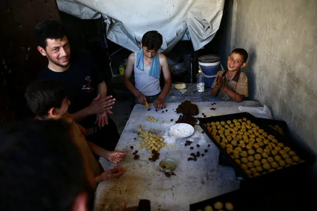 Men and boys prepare traditional sweets ahead of the Eid al-Fitr holiday marking the end of Ramadan in the rebel held besieged town of Douma, eastern Ghouta in Damascus, Syria July 3, 2016. (Photo by Bassam Khabieh/Reuters)
