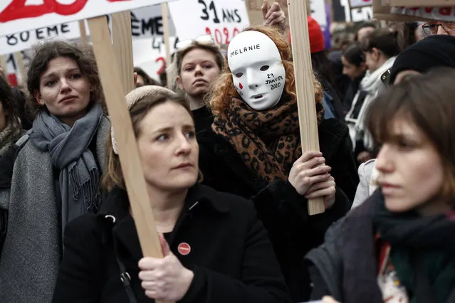 A woman wears a mask with the name of a woman, victim of domestic violence, during a march as part of the International Women's Day, in Paris, Sunday, March 8, 2020. (Photo by Thibault Camus/AP Photo)
