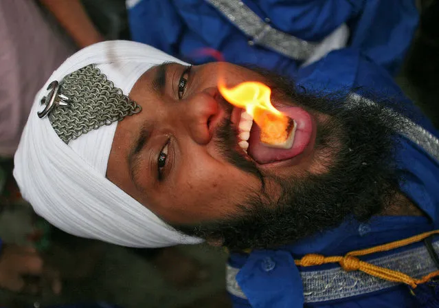A Sikh man performs with a burning camphor tablet on his tongue during celebrations to mark the 413th anniversary of the installation of the Guru Granth Sahib, the religious book of Sikhs, in Amritsar, India August 22, 2017. (Photo by Himanshu Sharma/Reuters)