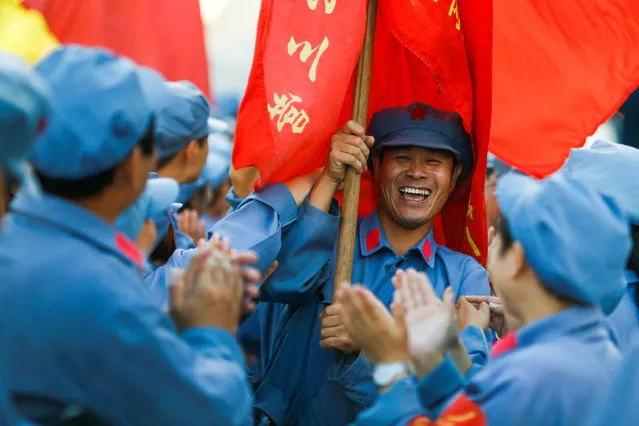 Participants dressed in replica red army uniforms welcome team mates as they return from a hike through the mountains during a Communist team-building course extolling the spirit of the Long March outside Jinggangshan, Jiangxi province, China, September 14, 2017. (Photo by Thomas Peter/Reuters)