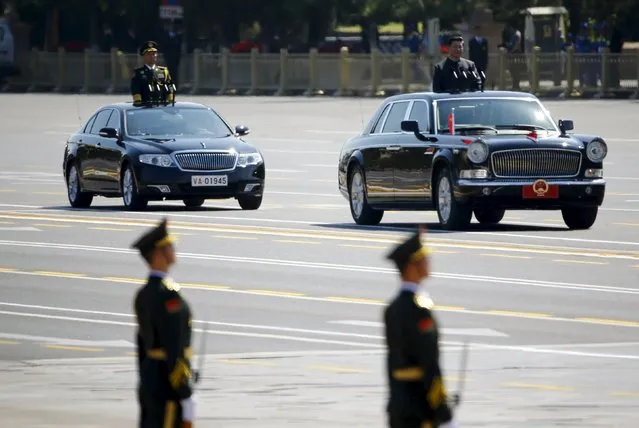 Chinese President Xi Jinping stands in a car (R) after he reviewed the army, during the military parade marking the 70th anniversary of the end of World War Two, in Beijing, China, September 3, 2015. (Photo by Damir Sagolj/Reuters)