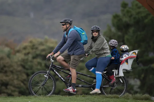 A family go for a bike ride on the outskirts of Wellington on April 20, 2020. New Zealand will ease a nationwide COVID-19 lockdown next week after claiming success in stopping “an uncontrolled explosion” of the virus, Prime Minister Jacinda Ardern said on April 20. (Photo by Marty Melville/AFP Photo)