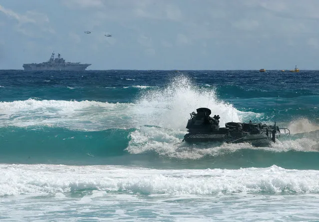 An amphibious assault vehicle drives through the waves during a simulated beach assault at Marine Corps Base Hawaii with the 3rd Marine Expeditionary Unit during the multi-national military exercise RIMPAC in Kaneohe, Hawaii, July 30, 2016. (Photo by Hugh Gentry/Reuters)