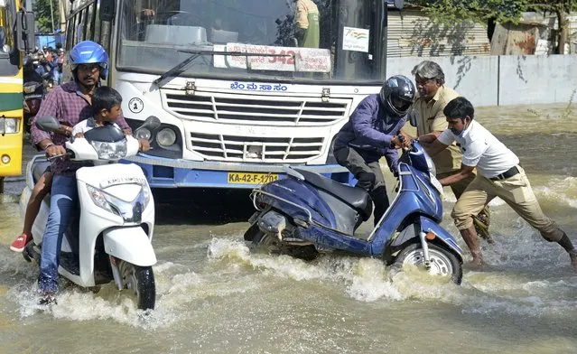 A motorist falls while navigating his way through a flooded street after heavy rainfall in Bangalore, India, Monday, September 5, 2022. (Photo by Kashif Masood/AP Photo)