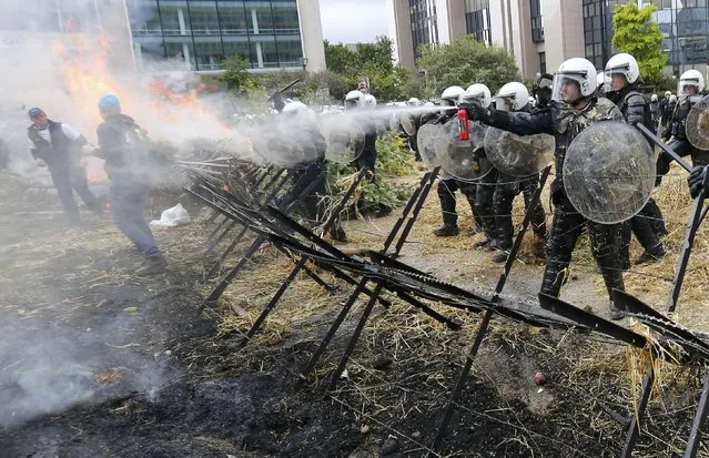 Belgian riot police officers clash with protesters as farmers and dairy farmers from all over Europe take part in a demonstration outside an European Union farm ministers emergency meeting at the EU Council headquarters in Brussels, Belgium, September 7, 2015. (Photo by Yves Herman/Reuters)
