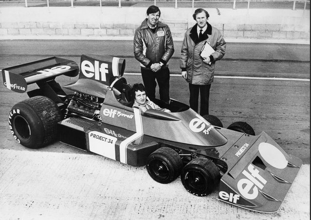 Team owner Ken Tyrrell (left) standing with Derek Gardner, designer of the Tyrrell P34 ( Project 34 )while Patrick Depailler of France sits aboard the radical six wheeled Elf Team Tyrrell Formual One Grand Prix car in the pitlane at Silverstone following the cars trial shakedown run on 9 October 1975 at the Silverstone Circuit, Towcester, United Kingdom. (Photo by Central Press/Hulton Archive/Getty Images).