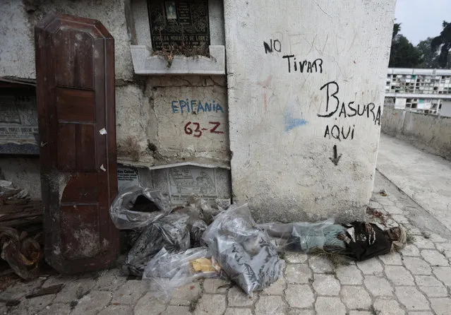 The mummified body of a woman lies on the floor and next to a wall with the writing “No littering here” during exhumation works at the Verbena cemetery in Guatemala City April 17, 2013. (Photo by Jorge Dan Lopez/Reuters)