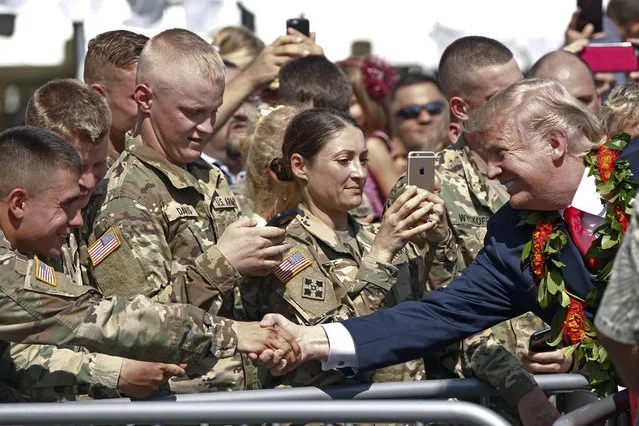 President Donald Trump greets servicemen after arriving aboard Air Force One, Friday, November 3, 2017 at Joint Base Pearl Harbor Hickam in Honolulu. (Photo by Jamm Aquino/The Star-Advertiser via AP Photo)