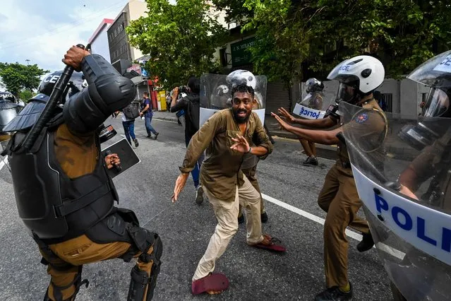 A Sri Lankan university student clashes with police during a demonstration in Colombo on August 18, 2022. (Photo by Ishara S. Kodikara/AFP Photo)