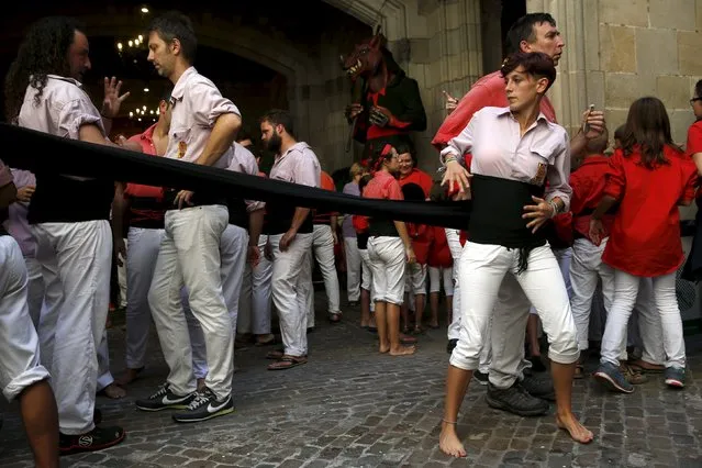 A member of the “Castellers Minyons de Terrassa” adjusts her belt before forming a human tower or ÒcastellÓ during the festival of the patron saint of Barcelona “The Virgin of Mercy” at Sant Jaume square in Barcelona, Spain, September 20, 2015. The formation of human towers is a tradition in Catalonia dating back to the 18th century. (Photo by Susana Vera/Reuters)