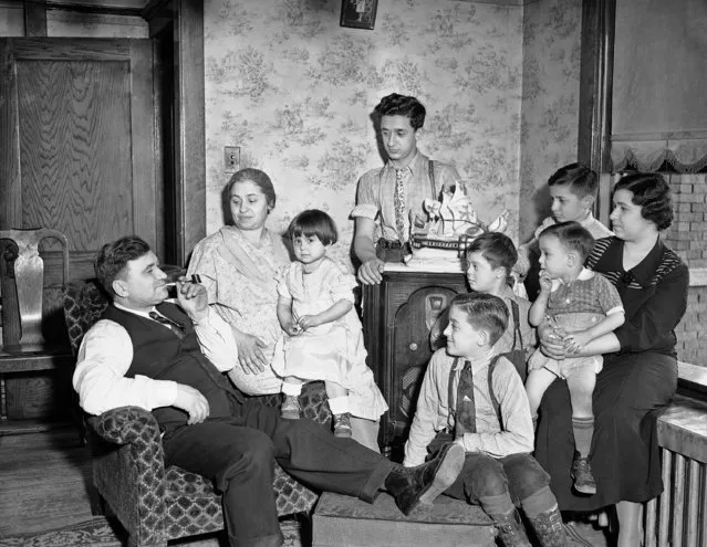 Frank Esposito finds comfort and happiness surrounded by his family after his duties as a worker in Illinois steel company's plant are completed for the day in south Chicago, March 3, 1937. Left to right: Esposito, his wife, Theresa holding Jean, 3; Jerry 15; John 12; Tom 10; Joe 7, and Della Fionda, his daughter, holding Joe, 2. (Photo by AP Photo)