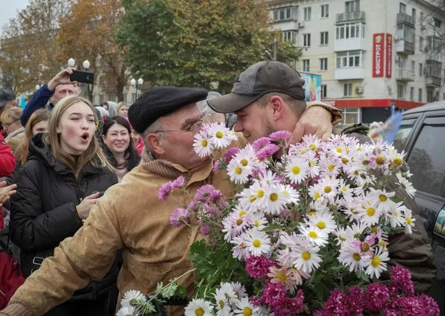 A local resident hugs Ukrainian serviceman as people celebrate after Russia's retreat from Kherson, in central Kherson, Ukraine on November 12, 2022. (Photo by Lesko Kromplitz/Reuters)