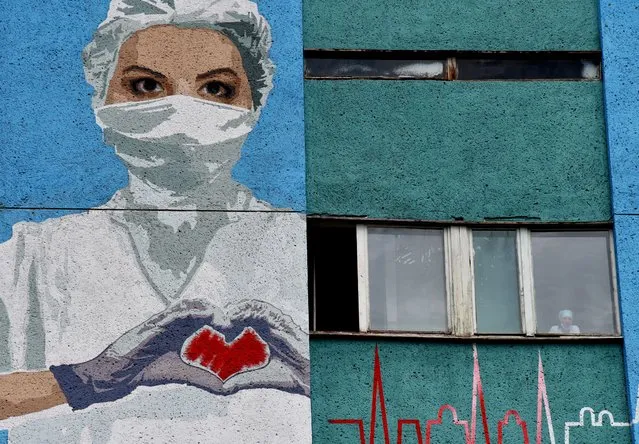 A mural depicting a healthcare worker is seen painted on a wall of the City Emergency Hospital, amid the coronavirus disease (COVID-19) outbreak in Lviv, Ukraine on June 21, 2020. (Photo by Pavlo Palamarchuk/Reuters)