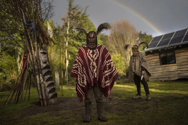 Mapuche men pose for a photo wearing kollon, or ceremonial masks, outside their home in Carimallin, southern Chile, on Friday, July 1, 2022. They are in charge of driving away negative energies during the multiday ceremonies of We Tripantu, the Mapuche new year. (Photo by Rodrigo Abd/AP Photo)