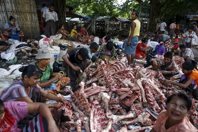People remove meat from the bones of animals slaughtered for Eid al-Adha after they have been discarded at a garbage dump in Yangon, Myanmar, September 25, 2015. (Photo by Soe Zeya Tun/Reuters)