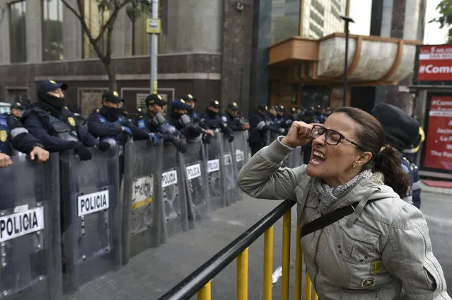 A demonstrator shouts slogans in front of the Senate building during a protest against the potential approval of an Internal Security Law which would allow the army to act as police, in Mexico City, on December 14, 2017. Mexican deputies approved a new security law which provides a legal framework for military deployment, the controversial initiative is being discussed in the Senate. (Photo by Yuri Cortez/AFP Photo)