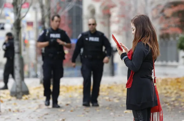 Police approach a woman while clearing a downtown area following shootings in downtown Ottawa October 22, 2014. (Photo by Blair Gable/Reuters)