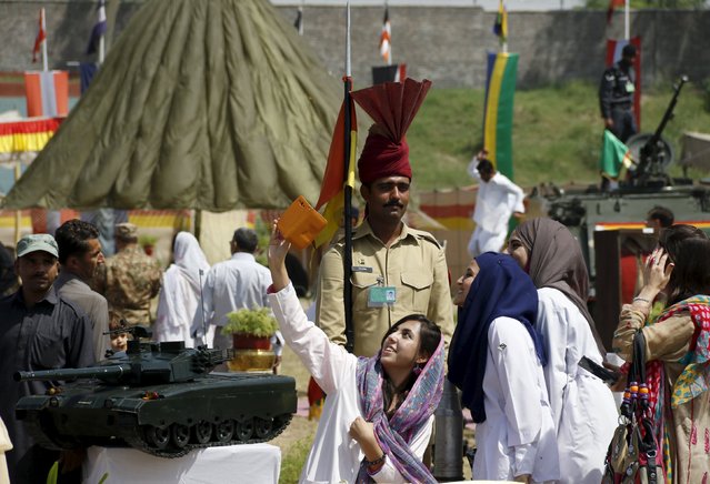 Women take a selfie while visiting an exhibition organised by the Pakistan Air Force (PAF) in Peshawar, Pakistan, September 6, 2015. Pakistanis are celebrating the golden jubilee of Pakistan Defence Day in memory of the martyrs of the 1965 war who defended the motherland against the powerful Indian Army in the Indo-Pak war. (Photo by Khuram Parvez/Reuters)