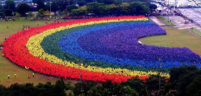 Some 31,000 students, faculty and alumni of the Polytechnic University of the Philippines create a “human rainbow” at the central park of the Philippine capital, September 18, 2004 in Manila. The rainbow was intended to boost the image of the school and set a new record for world's largest human rainbow in the Guinness Book of World Records. (Photo by AFP Photo)