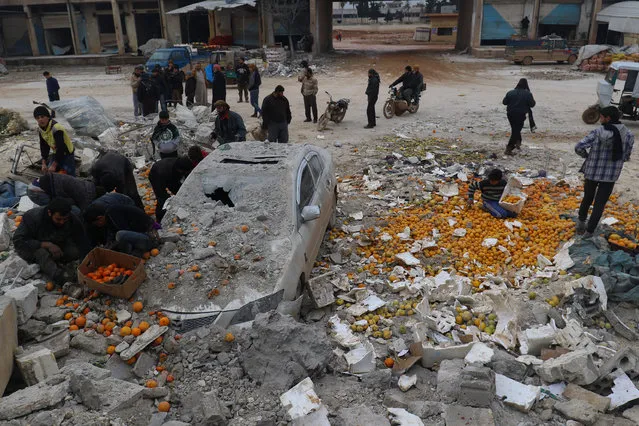 People collect scattered oranges amidst rubble after an airstrike on a market in rebel held Maarrat Misrin city in Idlib province, Syria January 14, 2017. (Photo by Ammar Abdullah/Reuters)