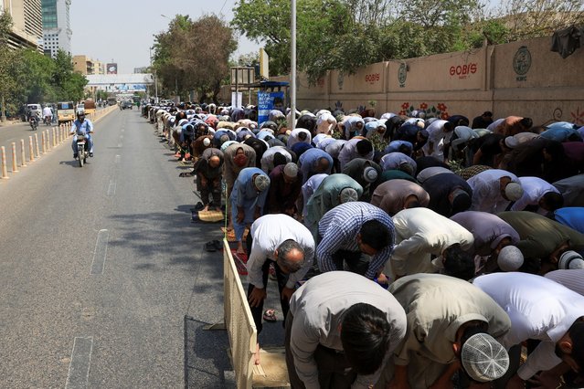 People attend Friday prayers during the Muslim holy month of Ramadan, outside a mosque, along a road in Karachi, Pakistan on March 21, 2025. (Photo by Akhtar Soomro/Reuters)
