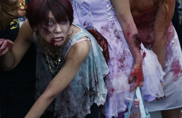 Participants wearing costumes and make-up as zombies march during a Halloween event to promote the U.S. TV series “The Walking Dead” at Tokyo Tower October 31, 2013. (Photo by Issei Kato/Reuters)