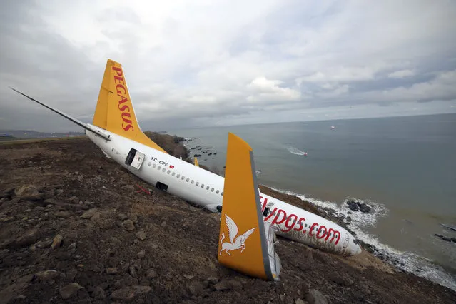 A Boeing 737-800 of Turkey's Pegasus Airlines is seen in Trabzon, Turkey, Monday, January 15, 2018. A commercial airplane that skidded off a runway after landing in northern Turkey dangled precariously Sunday off a muddy cliff with its nose only a few feet from the Black Sea.Some of the 168 people on board the Boeing 737-800 described it as a “miracle” that everyone was evacuated safely from the plane, which went off a runway at Trabzon Airport. (Photo by DHA-Depo Photos via AP Photo)