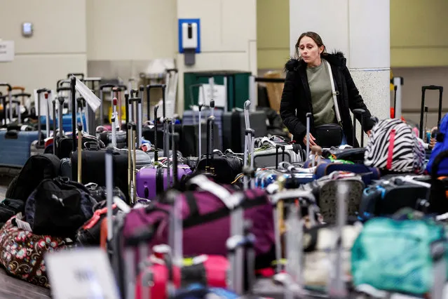 A Southwest Airlines traveler looks for her baggage in a pile of lost suitcases after an arctic blast and a massive winter storm dubbed Elliott swept over much of the United States in the lead-up to the Christmas holiday weekend, at Chicago Midway International Airport in Chicago, Illinois, U.S., December 27, 2022. (Photo by Kamil Krzaczynski/Reuters)