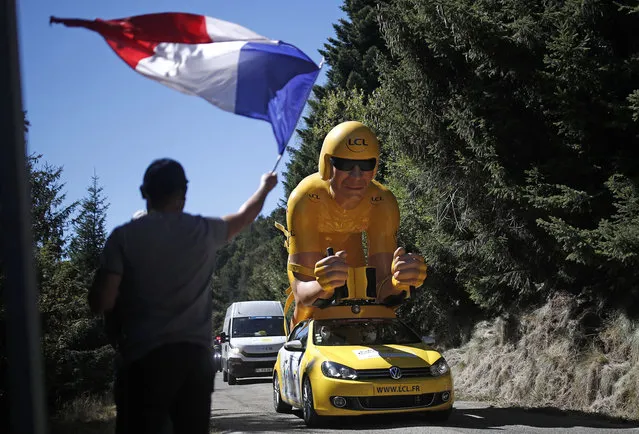 The caravan passes a man waving a French flag of Stage 6 Tour de France in France on September 3, 2020. (Photo by Stephane Mahe/Reuters)