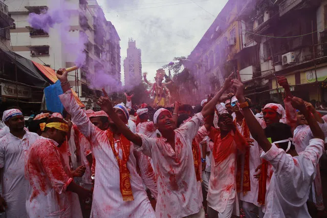 Hindu devotees participate in a procession towards the Arabian Sea where a giant idol of the elephant-headed god Ganesha will be immersed on the final day of the ten-day long Ganesha Chaturthi festival in Mumbai, India, Thursday, September 15, 2016 . The last day of the 10-day celebration is the biggest day, with massive crowds singing and dancing as they carry their idols through the streets, to immerse them in the water, an act that symbolizes sending the god back to his mythical home in the snow-capped mountains taking all the worries and problems of his worshippers with him. (Photo by Rafiq Maqbool/AP Photo)