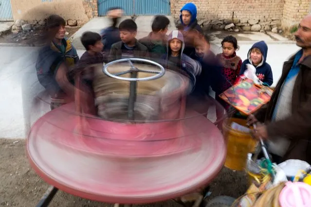 Afghan boys play outside their home in Kabul on January 10, 2023. (Photo by Wakil Kohsar/AFP Photo)