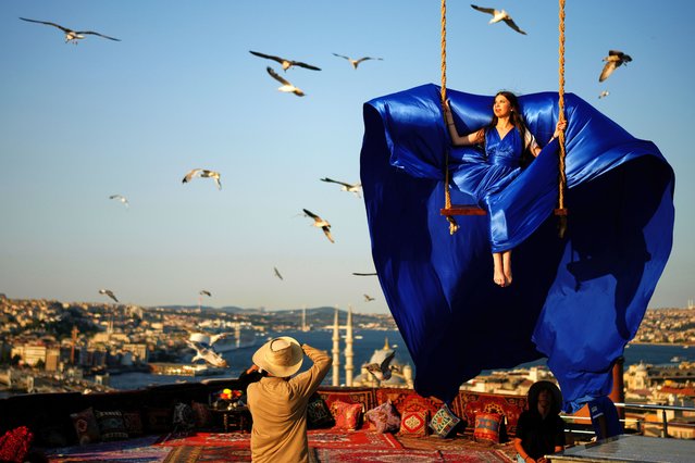 A tourist takes photos in an open-air studio with a view of the Bosphorus in Istanbul, Turkey, Saturday, July 19, 2025. (Photo by Emrah Gürel/AP Photo)