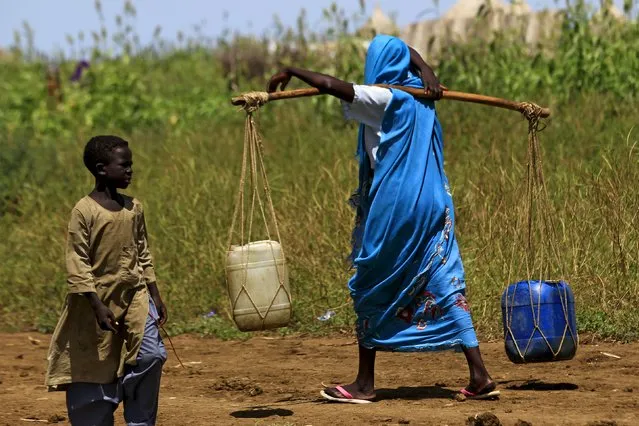 A woman carries water during a visit by a European Union delegation, at an Internally Displaced Persons (IDP) camp in Azaza, east of Ad Damazin, capital of Blue Nile state, Sudan October 21, 2015. (Photo by Mohamed Nureldin Abdallah/Reuters)