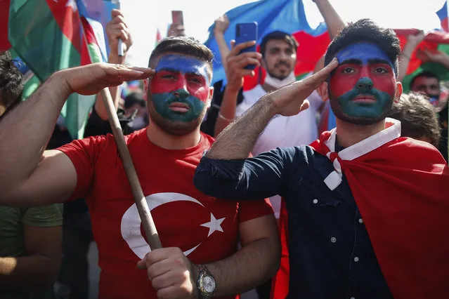 Demonstrators, their faces covered with the colours of the flag of Azerbaijan, salute during a protest supporting Azerbaijan, in Istanbul, Sunday, October 4, 2020. Armenian and Azerbaijani forces continue their fighting over the separatist region of Nagorno-Karabakh, following the reigniting of a decades-old conflict. Turkey, which strongly backs Azerbaijan, has condemned an attack on Azerbaijan's second largest city Gence and said the attack was proof of Armenia's disregard for law. (Photo by Emrah Gurel/AP Photo)