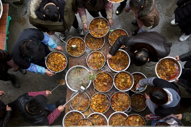 Villagers prepare a meal after slaughtering pigs, during a celebration ahead of the Lunar Chinese New Year, in Anshun, Guizhou province, China January 15, 2018. (Photo by Reuters/China Stringer Network)