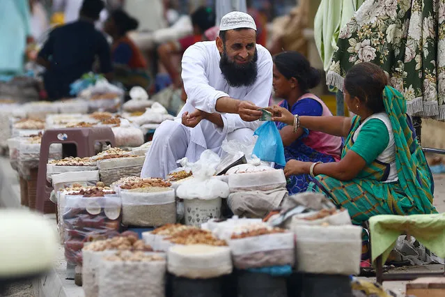 A Pakistani woman sells dry fruit on a road side after the government lifted most of the country's remaining coronavirus restrictions, in Karachi, Pakistan, 19 August 2020. (Photo by Shahzaib Akber/EPA/EFE/Rex Features/Shutterstock)